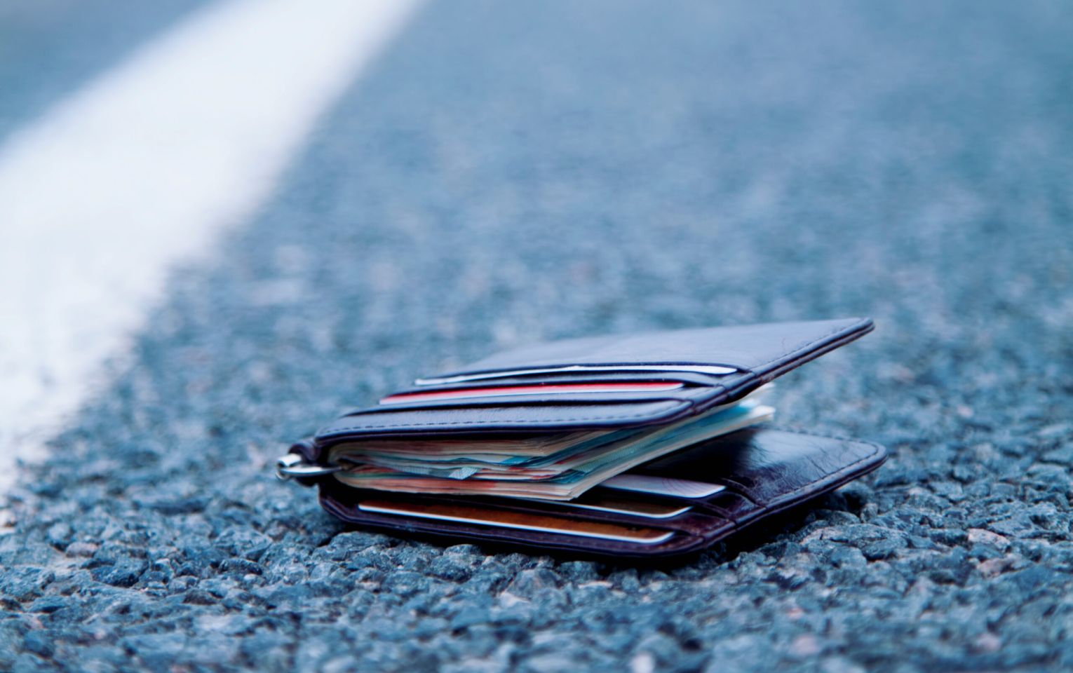 Wallet with money on the road. Wasted time is money lost concept.